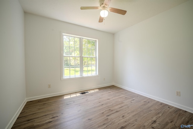 empty room with ceiling fan and hardwood / wood-style flooring