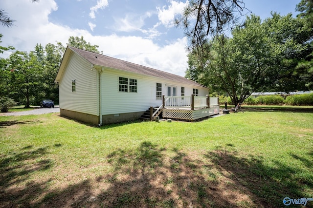 rear view of property with a yard and a wooden deck