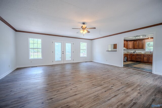 unfurnished living room featuring sink, french doors, ceiling fan, and wood-type flooring