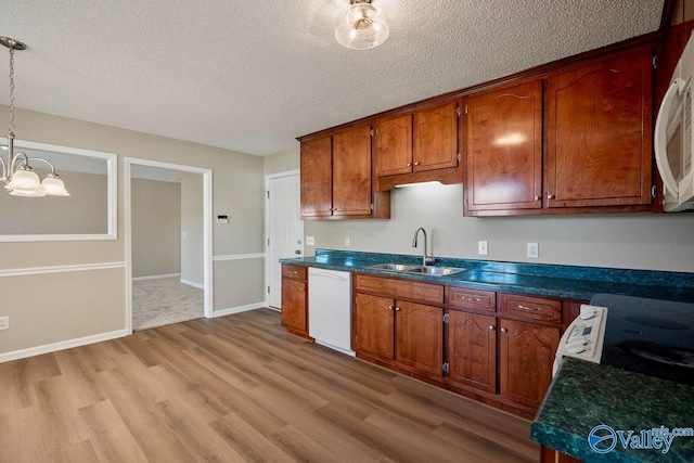 kitchen featuring a sink, a textured ceiling, light wood-type flooring, a chandelier, and white appliances
