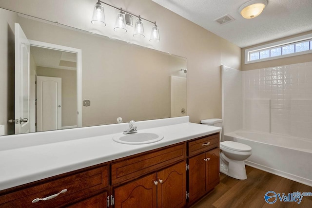 bathroom featuring wood finished floors, vanity, toilet, visible vents, and bathing tub / shower combination