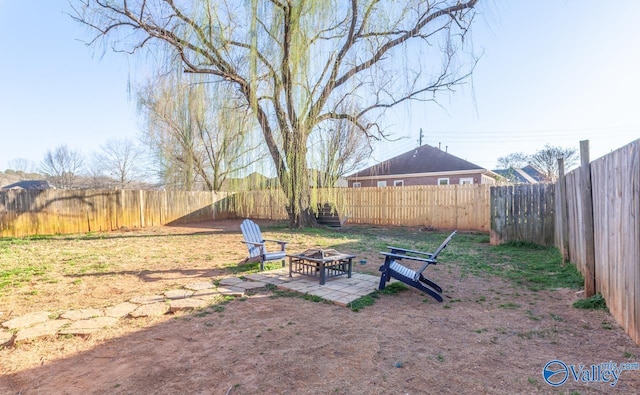 view of yard with a patio area, a fenced backyard, and an outdoor fire pit