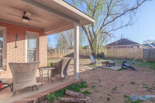 view of yard with ceiling fan, a fire pit, a fenced backyard, and a patio area