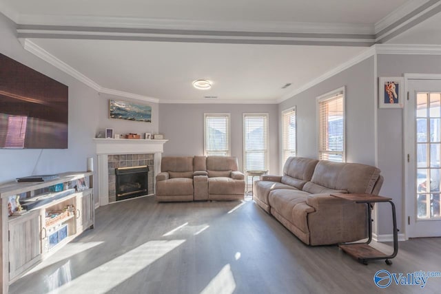 living room featuring ornamental molding, wood finished floors, and a tile fireplace