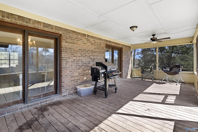 wooden terrace with area for grilling and a ceiling fan