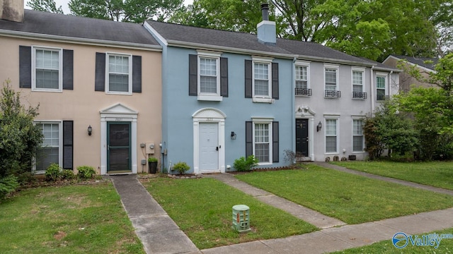 2823 Wynterhall Rd, Huntsville, AL 35803 - view of front of house featuring a front yard, a chimney, and stucco siding