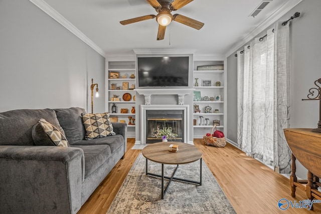 2823 Wynterhall Rd, Huntsville, AL 35803 - living area with built in shelves, crown molding, a ceiling fan, and wood finished floors