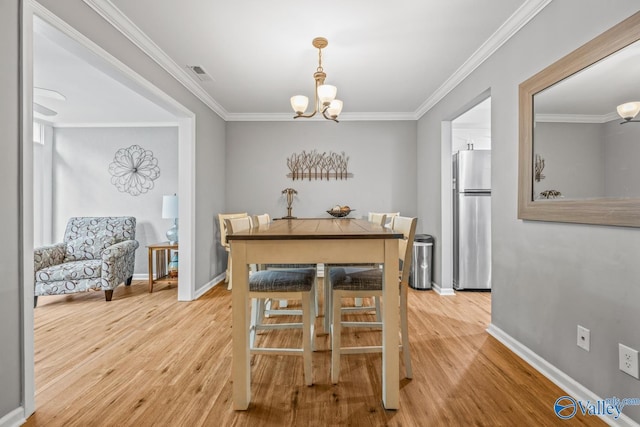 2823 Wynterhall Rd, Huntsville, AL 35803 - dining room with an inviting chandelier, visible vents, light wood-type flooring, crown molding, and baseboards