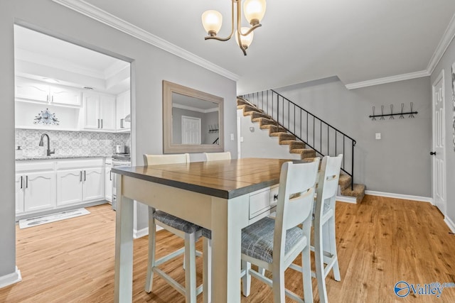 2823 Wynterhall Rd, Huntsville, AL 35803 - dining area featuring crown molding, a notable chandelier, stairs, and light wood finished floors