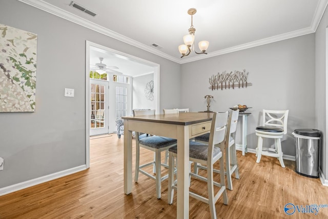 2823 Wynterhall Rd, Huntsville, AL 35803 - dining area with light wood-style flooring, baseboards, visible vents, ceiling fan with notable chandelier, and ornamental molding