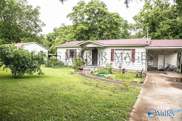 525 Quincy St, Scottsboro, AL 35768 - view of front of house featuring a carport, concrete driveway, a front yard, and metal roof