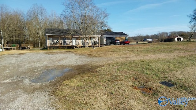 view of front of home with a carport, a front yard, and covered porch