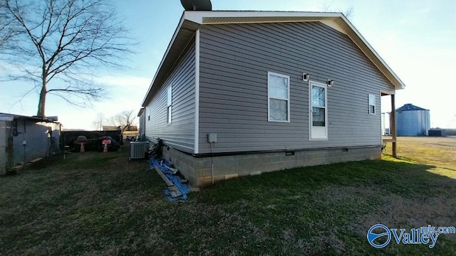 view of side of home featuring a yard and central air condition unit