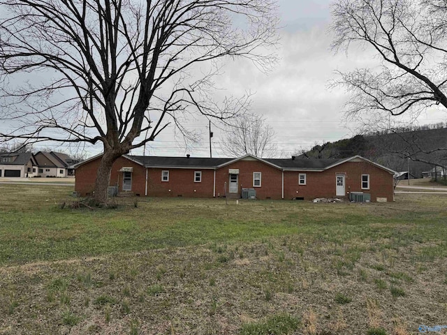 back of property with a lawn and central AC unit