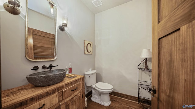 bathroom featuring toilet, hardwood / wood-style floors, and vanity