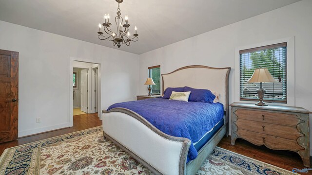 bedroom with a notable chandelier and dark hardwood / wood-style floors