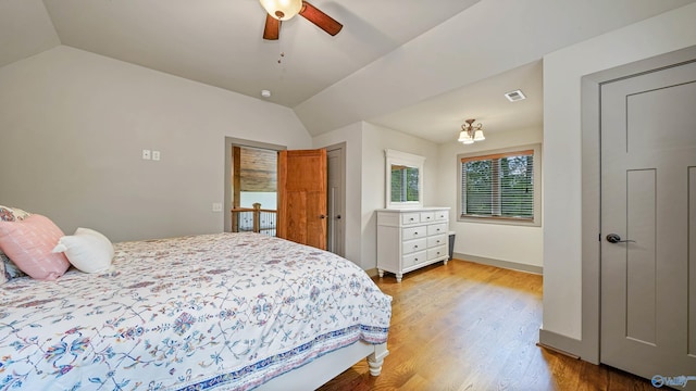 bedroom with light hardwood / wood-style floors, vaulted ceiling, and ceiling fan