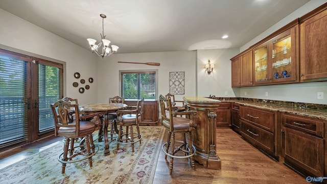 dining room featuring light wood-type flooring, a notable chandelier, and a wealth of natural light