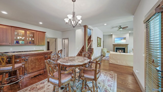 dining room featuring dark hardwood / wood-style floors and ceiling fan with notable chandelier