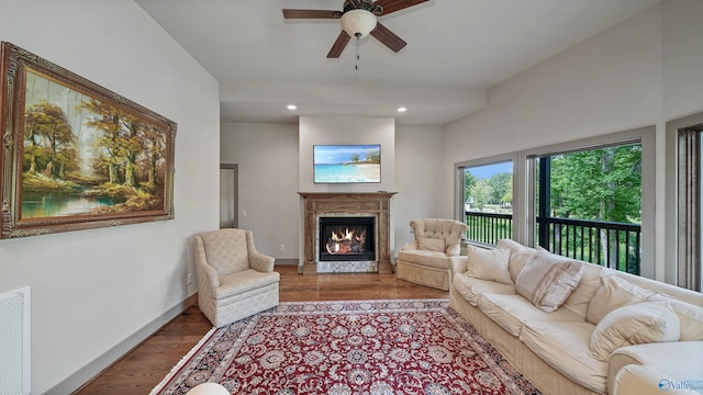 living room featuring ceiling fan, hardwood / wood-style floors, and a high end fireplace