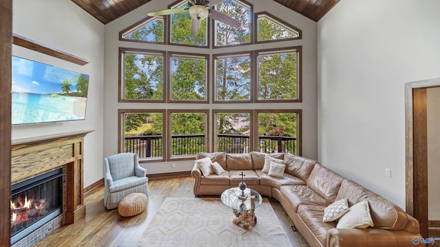 living room with light hardwood / wood-style flooring, plenty of natural light, and high vaulted ceiling