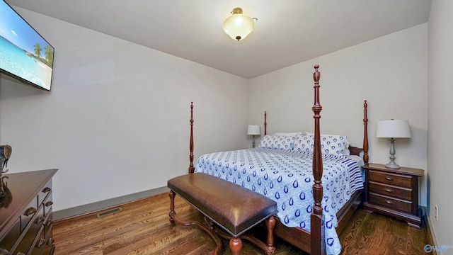 bedroom with dark hardwood / wood-style flooring