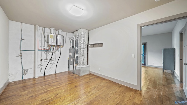 unfurnished room with water heater and light wood-type flooring