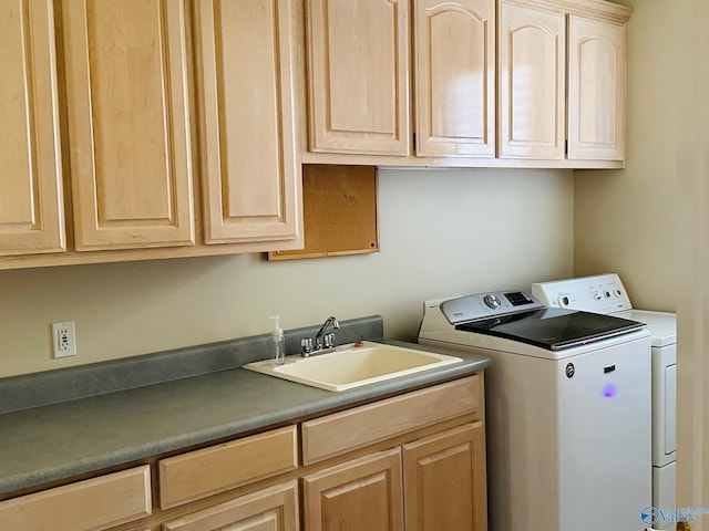 washroom featuring washing machine and clothes dryer, sink, and cabinets