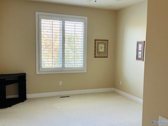 carpeted spare room featuring ceiling fan