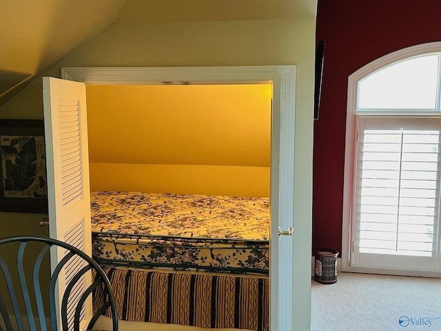 interior space featuring carpet floors and vaulted ceiling