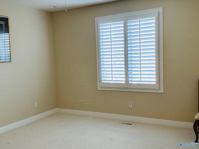 spare room with baseboards, carpet floors, and visible vents