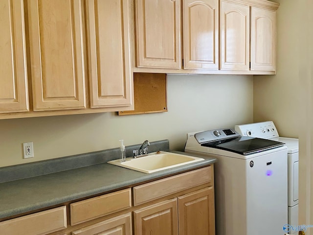laundry area with independent washer and dryer, cabinet space, and a sink