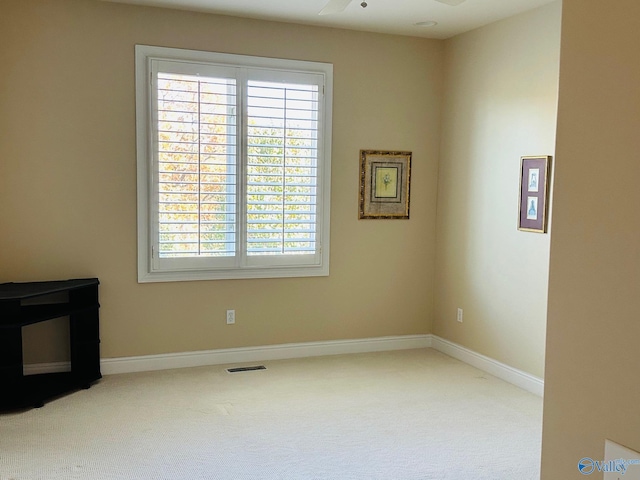 interior space with baseboards, visible vents, carpet floors, and a ceiling fan