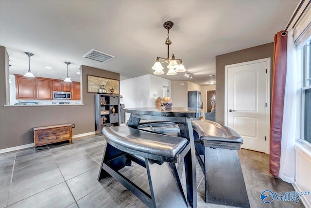 tiled dining area with an inviting chandelier