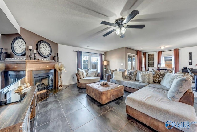 living room featuring a textured ceiling, dark tile patterned flooring, and ceiling fan