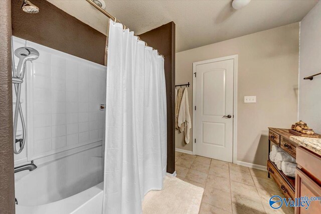 bathroom with vanity, a textured ceiling, tile patterned floors, and shower / tub combo