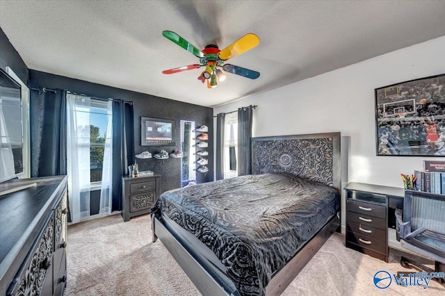 carpeted bedroom featuring a textured ceiling and ceiling fan