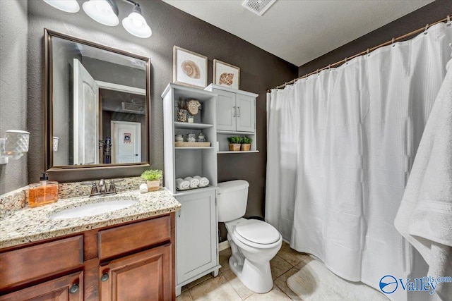 bathroom featuring toilet, tile patterned flooring, a shower with curtain, vanity, and a textured ceiling