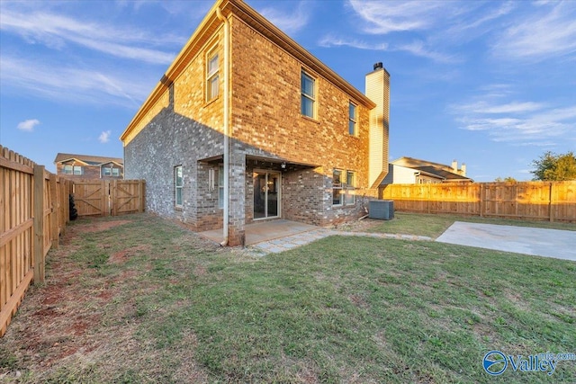 back of property with a patio, a lawn, and central air condition unit