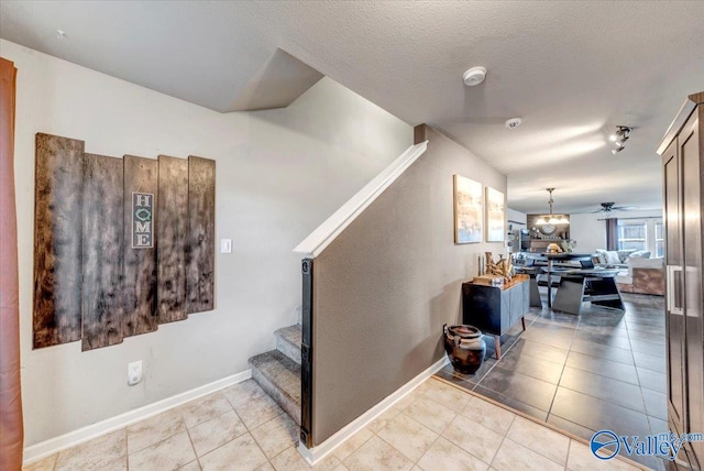 stairs featuring ceiling fan, tile patterned floors, and a textured ceiling