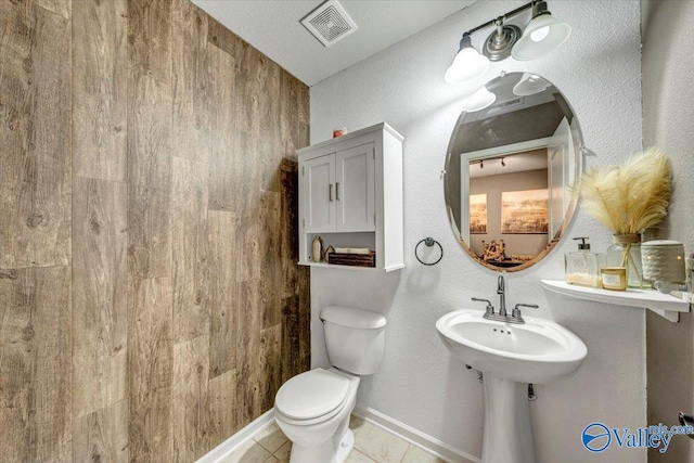 bathroom with tile patterned floors, a textured ceiling, and toilet