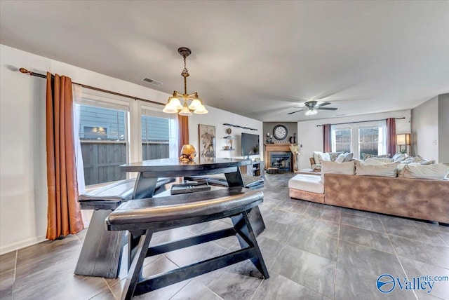 dining room featuring ceiling fan with notable chandelier