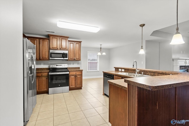 kitchen with sink, stainless steel appliances, pendant lighting, a chandelier, and light tile patterned flooring