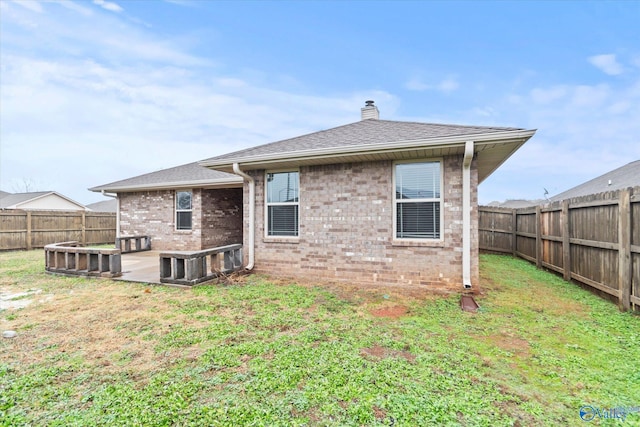 back of property with a yard and a patio