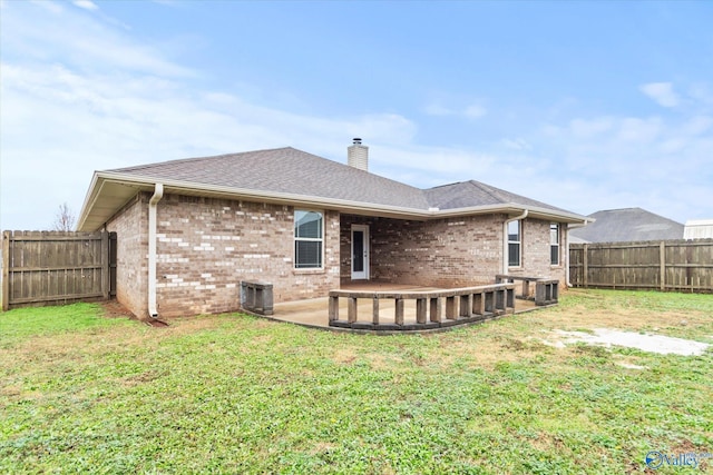 back of property with central air condition unit and a lawn