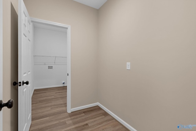 laundry area featuring laundry area, light wood finished floors, hookup for a washing machine, and baseboards