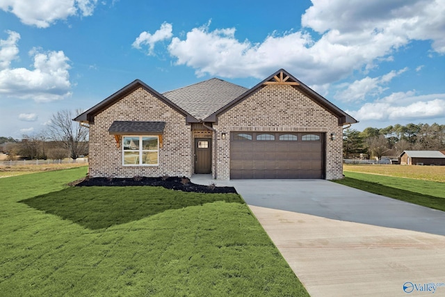 view of front of home featuring brick siding, a shingled roof, a front yard, a garage, and driveway