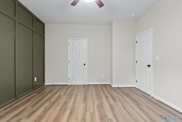 unfurnished bedroom with a ceiling fan, light wood-style flooring, and baseboards