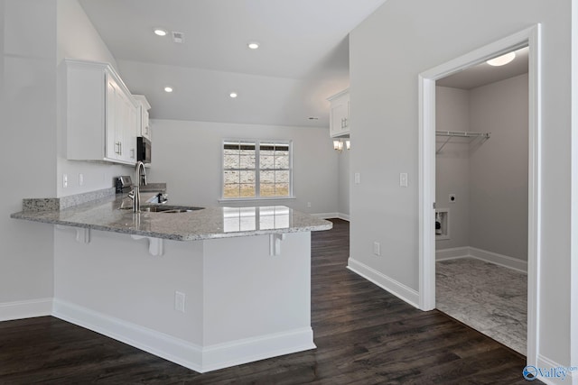 15354 Springbrook Trce, Athens, AL 35611 - kitchen featuring stainless steel microwave, light stone counters, a peninsula, a kitchen bar, and a sink