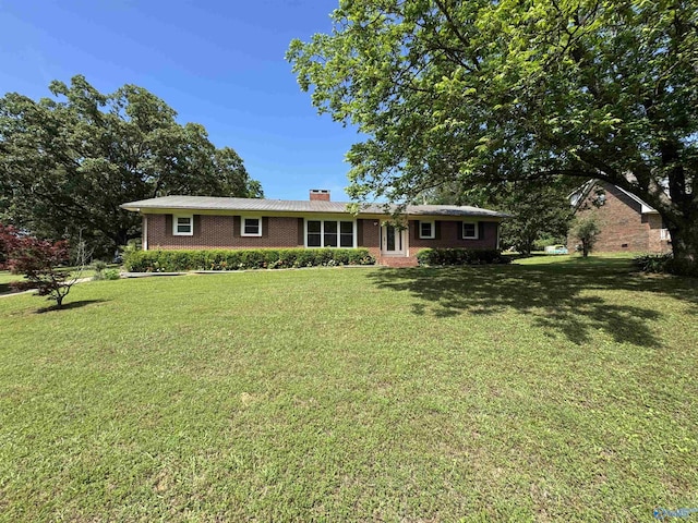 137 Winn Rd, Scottsboro, AL 35769 - ranch-style house featuring brick siding, a front yard, and a chimney